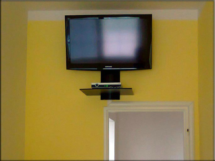 Montáž satelitních rozvodů na penzionu v Krušných horách. [Z důvodu omezeného místa, musel být jednolůžkový pokoj řešen instalací TV přijímače nad vchodovými dveřmi.]